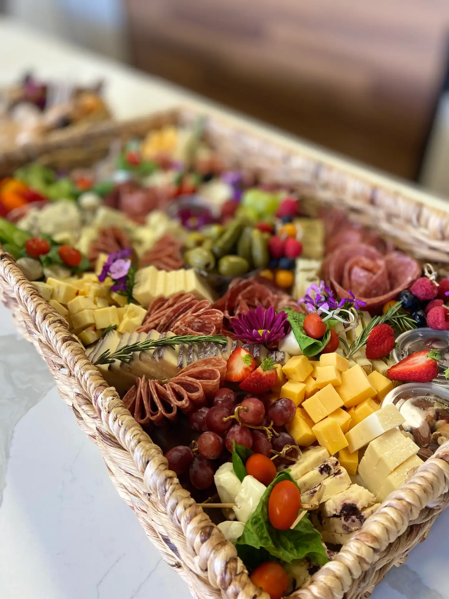 Side angle of BYOB charcuterie board with folded meats, cheeses, and colorful fruit display in Columbia SC