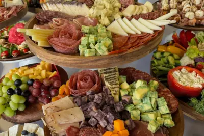 Traveling charcuterie board with meats, cheeses, fruits, and fresh vegetables