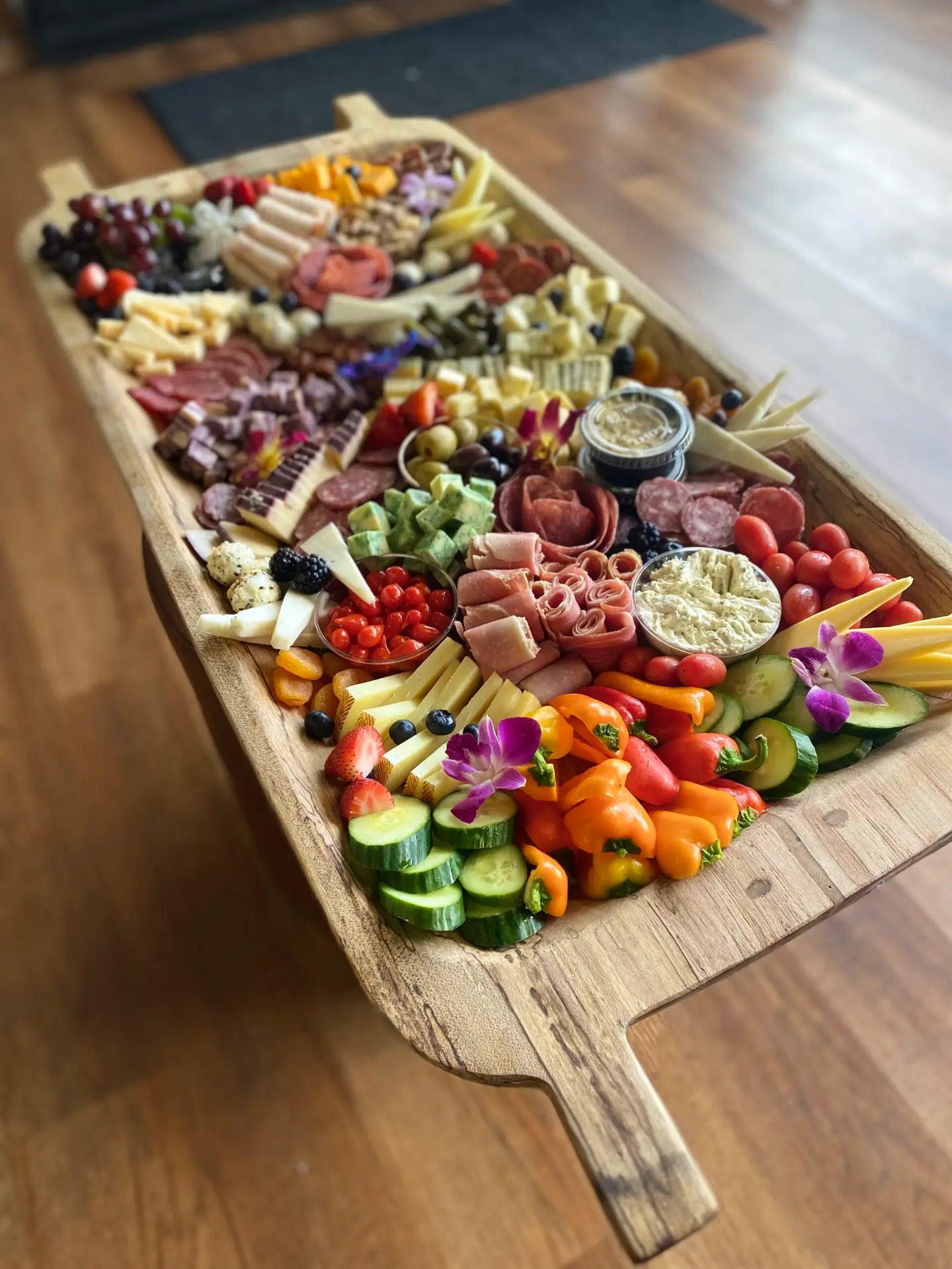 BYOB charcuterie spread on a large wooden serving board with colorful fruits, cheeses, and vegetables in Midlands SC