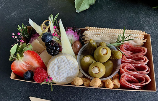 Single-serve charcuterie box with cheese, fruit, olives, and crackers
