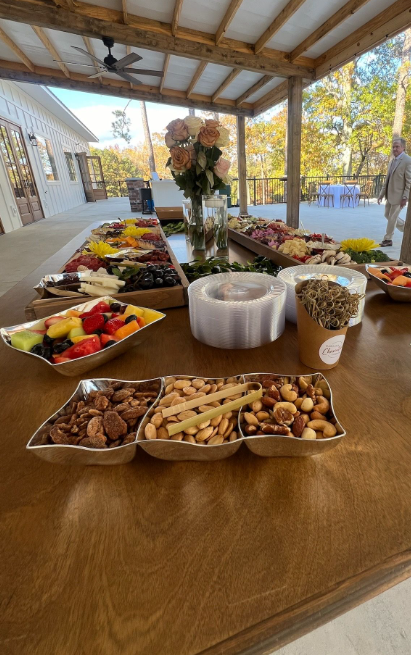Grazing table charcuterie catering setup outdoors under a covered pavilion