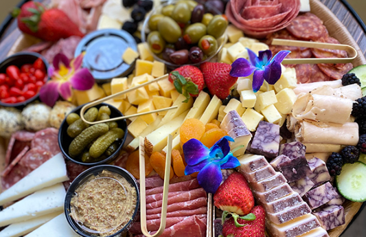 Grand Luxe charcuterie box with meats, cheeses, olives, fruit, and spreads