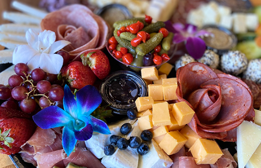 Luxe charcuterie box with gourmet meats, cheeses, crackers, and garnishes